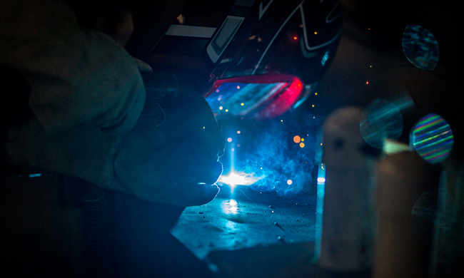 Worker weldering in a welding mask